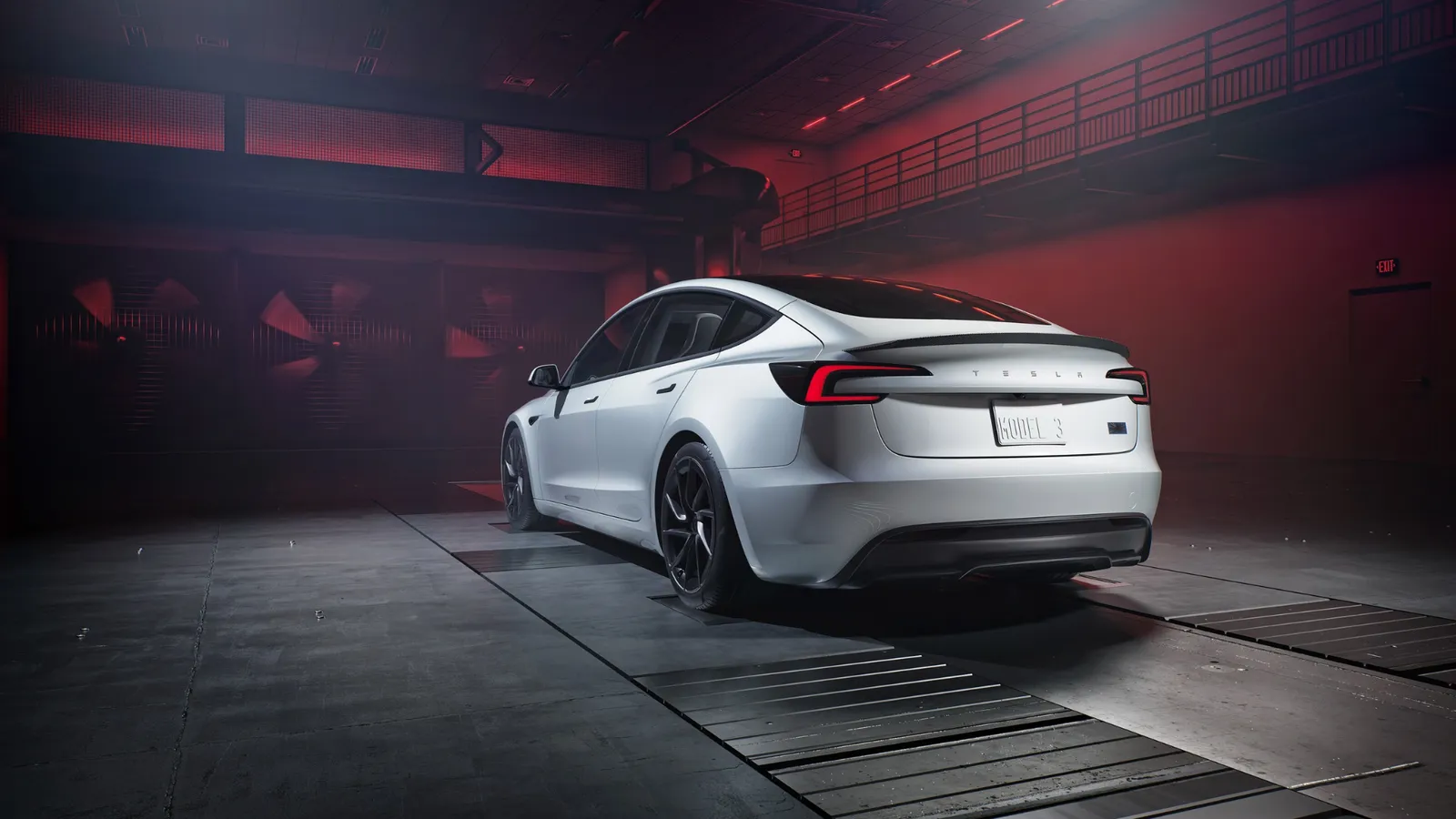 Tesla Model 3 blanco visto desde atrás, el coche eléctrico más vendido en septiembre de 2026, en una nave con luz roja