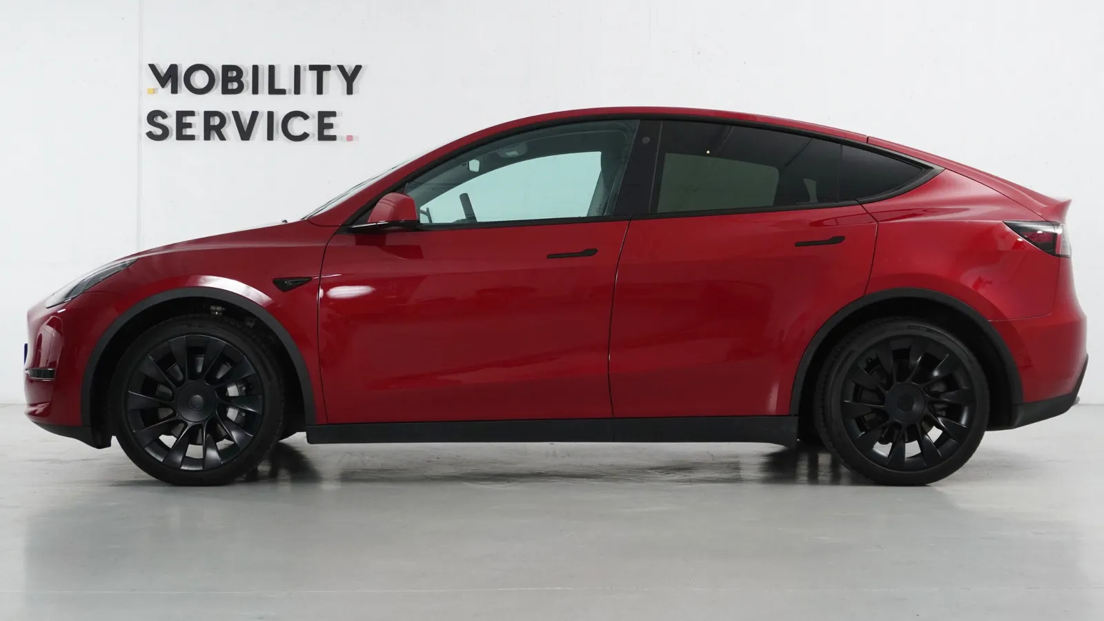 Tesla Model Y eléctrico rojo reacondicionado, visto de perfil en las instalaciones de Mobility Service